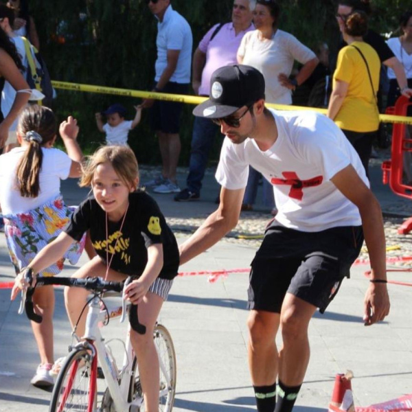 Un istruttore che accompagna un giovane ciclista a Natale con Più Sport