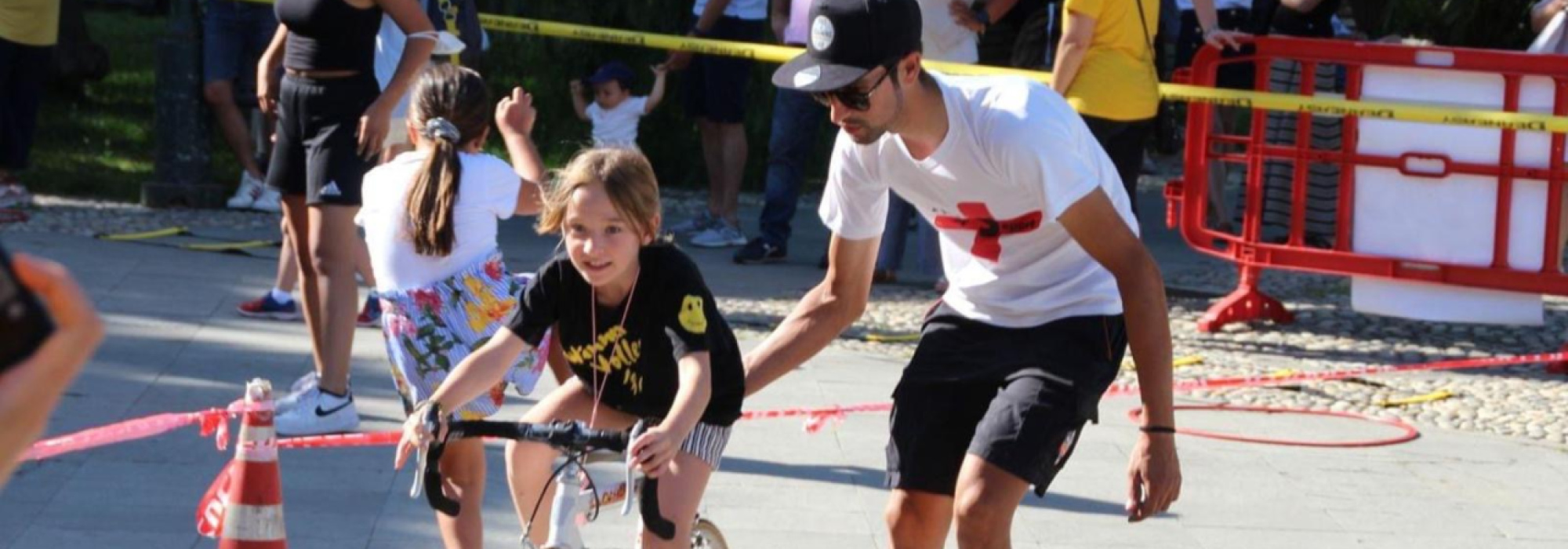 Un istruttore che accompagna un giovane ciclista a Natale con Più Sport